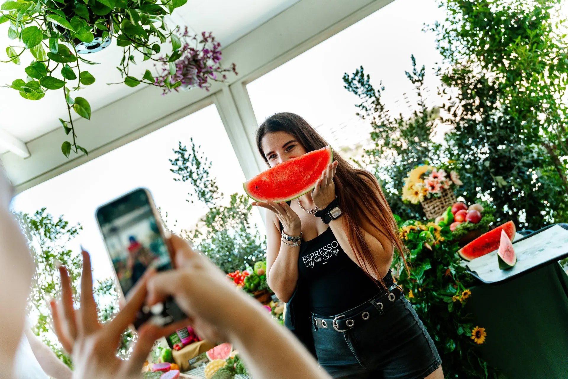 Guest posing with a watermelon slice for a phone photo